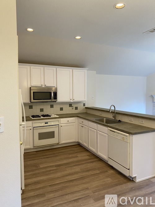 A kitchen with white cabinets and a microwave oven.