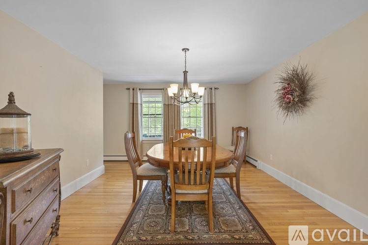 A dining room with a wooden table and chairs.