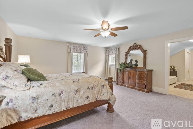 A bedroom with a large bed and a wooden dresser.