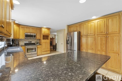 A kitchen with wooden cabinets and granite countertops.