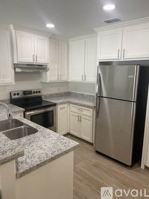 A kitchen with a granite countertop and stainless steel appliances.