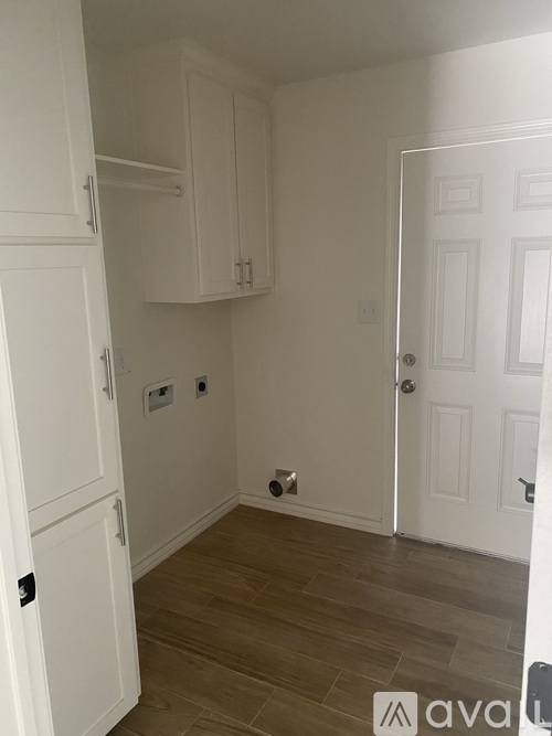 A white door is on the right and a white cabinet is on the left.