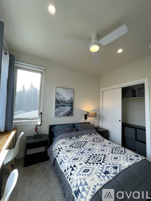 A bedroom with a bed, a lamp, and a picture on the wall.