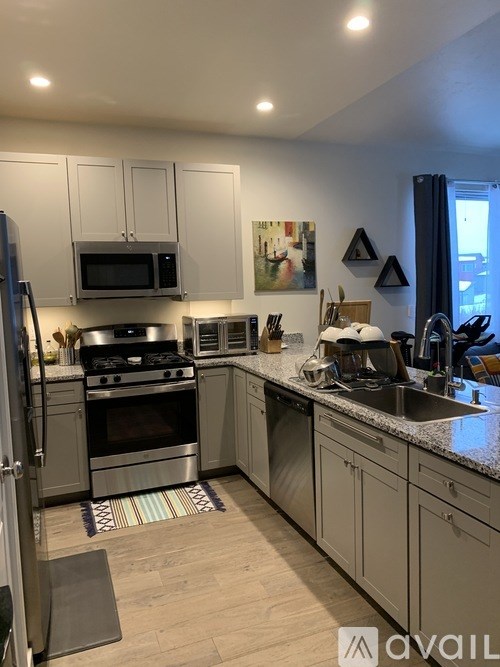 A kitchen with a refrigerator, stove, and microwave.