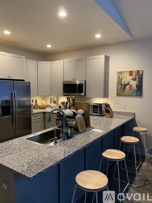 A kitchen with a blue counter and white cabinets.