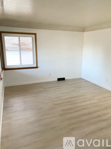 A room with wooden flooring and a window.
