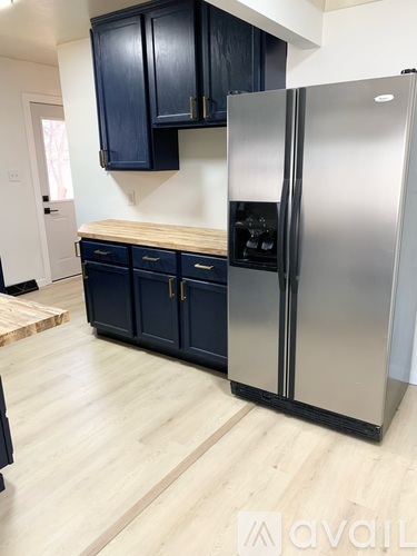 A kitchen with a stainless steel refrigerator and wooden countertops.