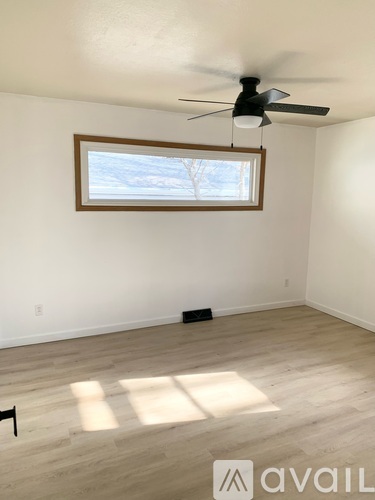 A room with a ceiling fan and a window.