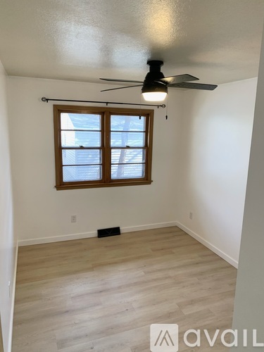 A room with a ceiling fan and a window.