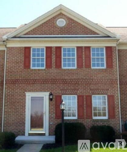 A brick house with a white door and windows.
