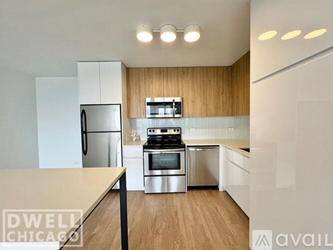 A modern kitchen with a stainless steel refrigerator, oven, and microwave.