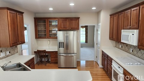 A kitchen with wooden cabinets and stainless steel appliances is available for rent.