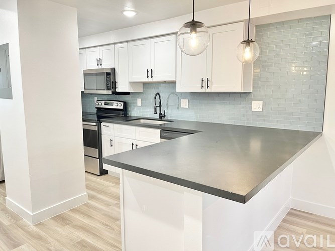 A modern kitchen with a stainless steel island and white cabinets.