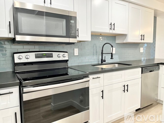 A kitchen with white cabinets and a black stove top oven.