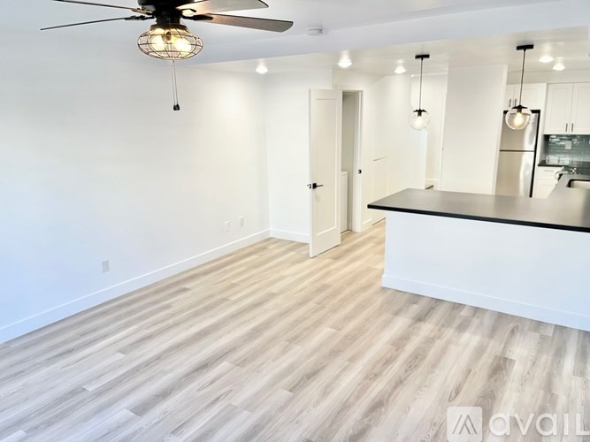 A spacious kitchen with a fan and pendant lights.