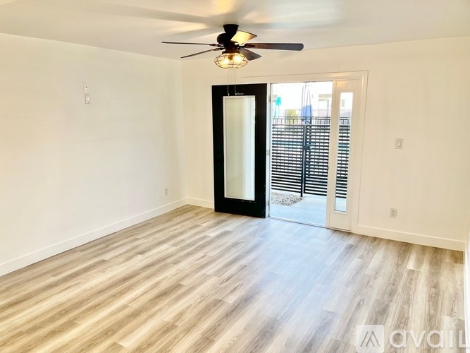 A room with a ceiling fan and a sliding glass door.