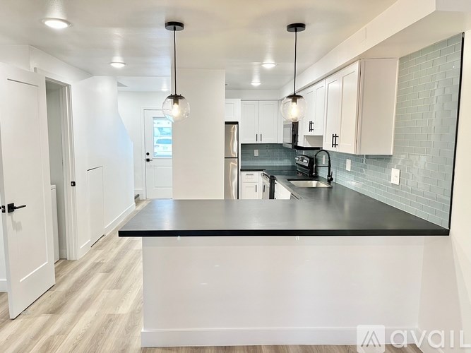 A kitchen with a black countertop and white cabinets.