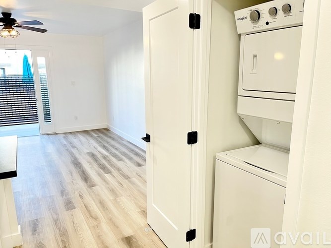 A white oven and microwave are installed in a kitchen with wood flooring.