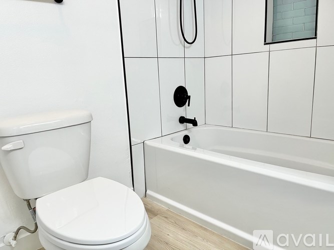 A white toilet sits next to a white bathtub in a bathroom.
