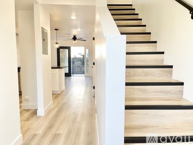 A staircase with wooden steps and a black handrail.