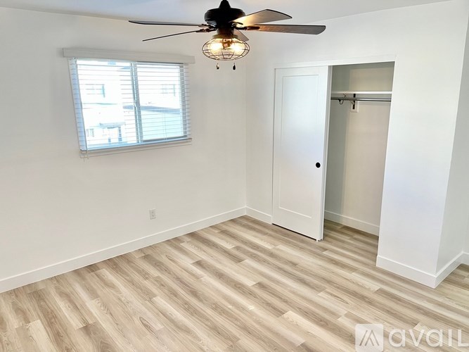 A room with a ceiling fan and a door.