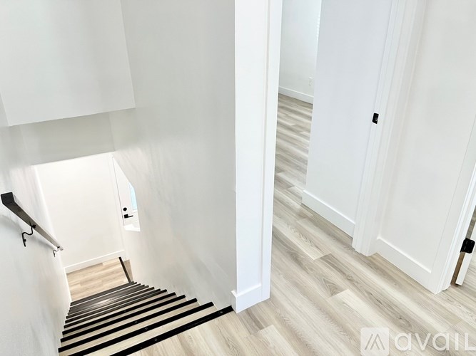 A hallway with a wooden floor and white walls.