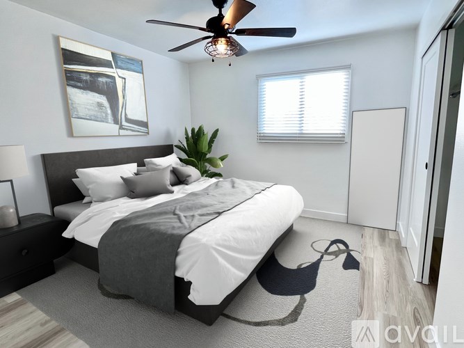 A modern bedroom with a large bed and a ceiling fan.