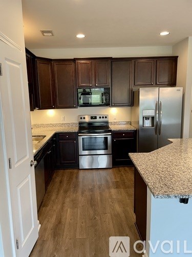 A kitchen with dark brown cabinets and stainless steel appliances.