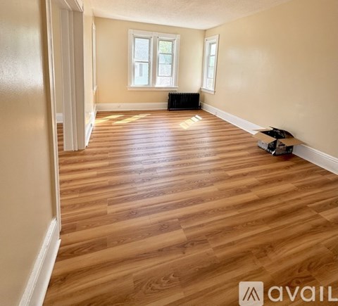 A white refrigerator is in a room with a door open.