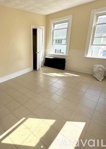 A room with wooden floors and a window overlooking a garden.