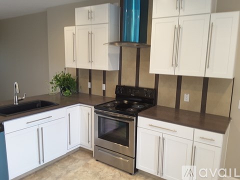 A kitchen with white cabinets and a black stove top oven.