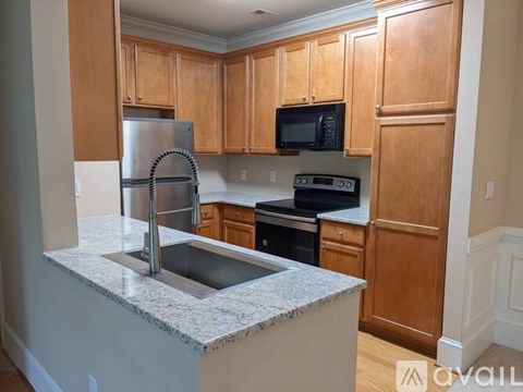 A kitchen with wooden cabinets and granite countertops.