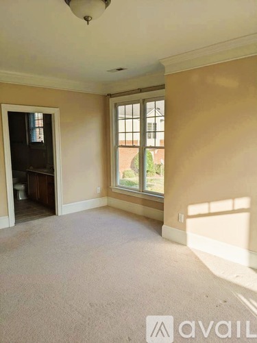 A room with a window and a door leading to another room.
