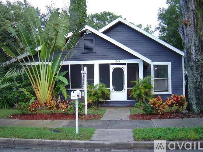A small blue house with a white door and windows.
