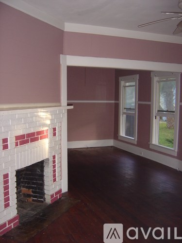 A room with a fireplace and a window.