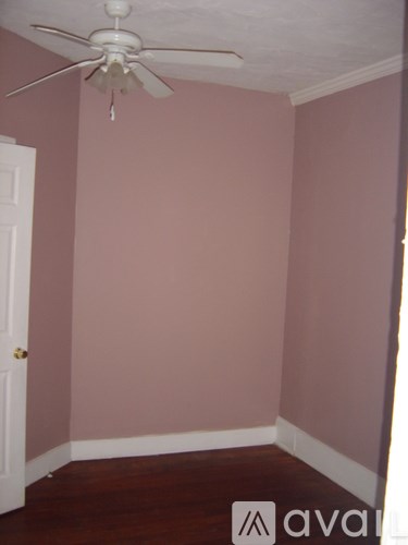 A room with a ceiling fan and a door.