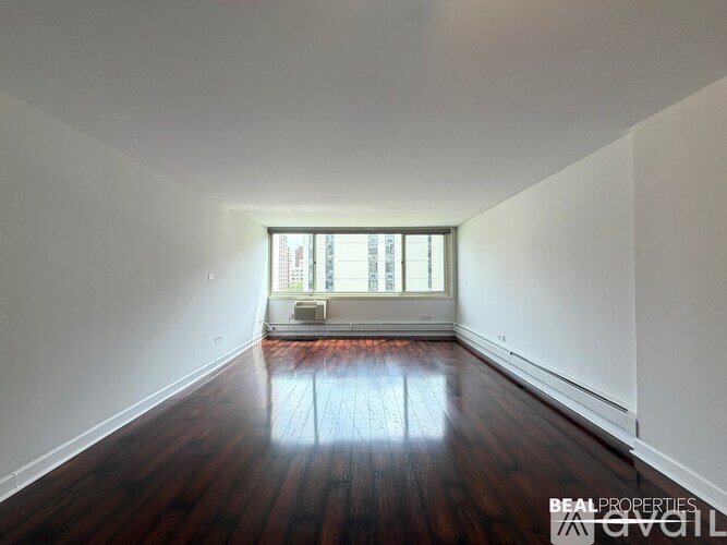 A room with wooden floors and a window is available for rent.