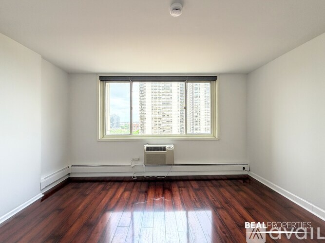 A white hallway with wood floors and a white door.