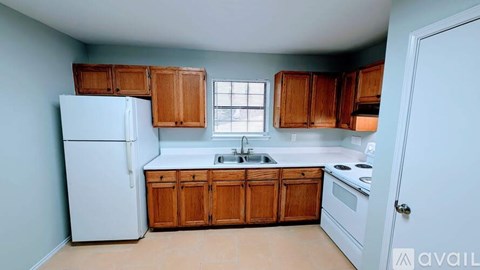 A kitchen with wooden cabinets and a white refrigerator.