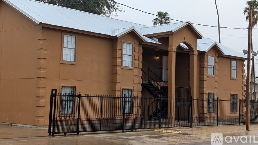 A brown building with a black fence in front.