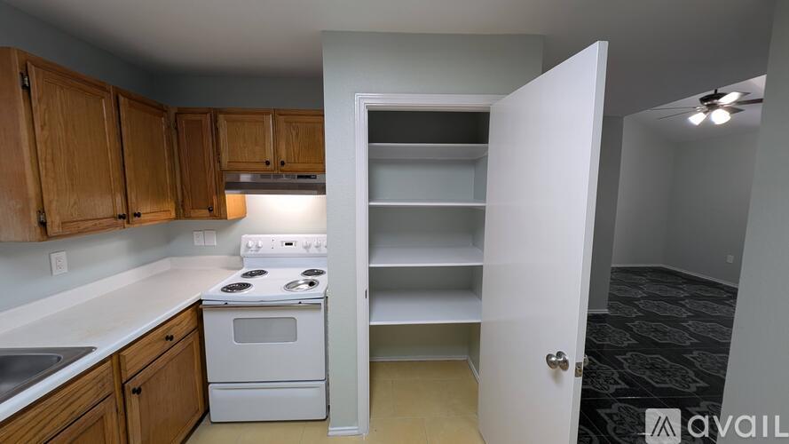 A kitchen with wooden cabinets and a white stove top oven.