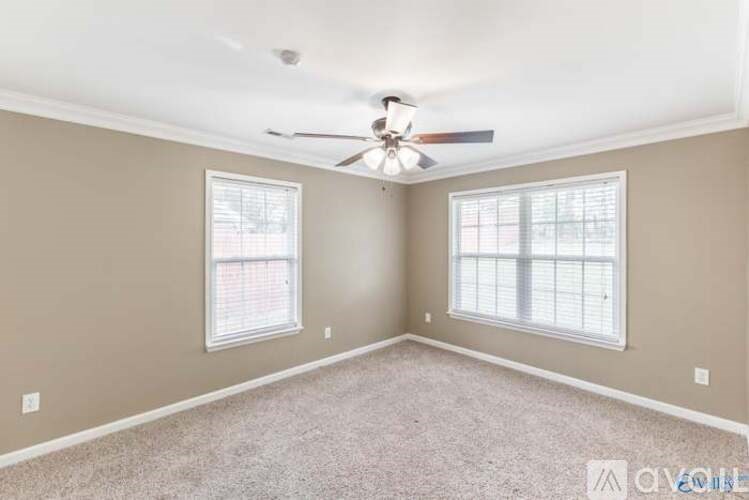 A room with a ceiling fan and two windows.