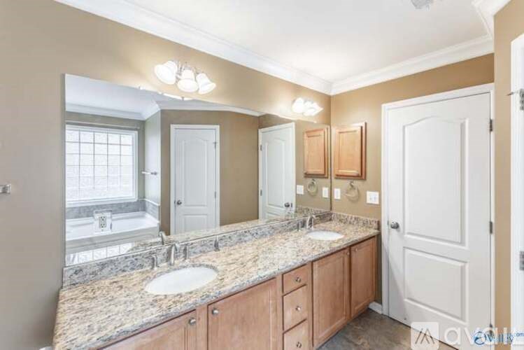 A bathroom with a marble countertop and double sinks.