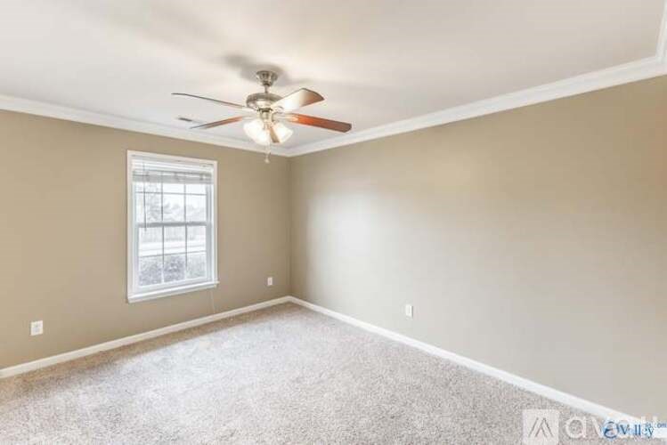 A room with a ceiling fan and a window.