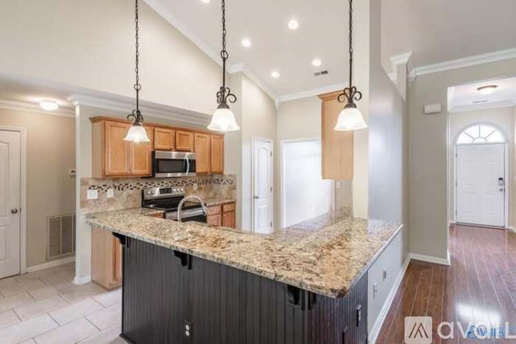A kitchen with granite countertops and a black dishwasher.