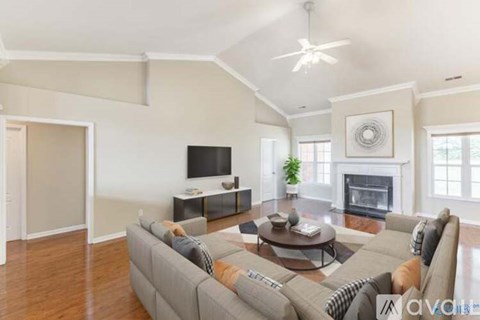 A living room with a grey couch and a fireplace.