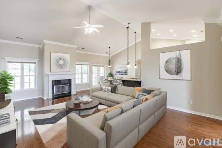 A living room with a grey couch and a fireplace.