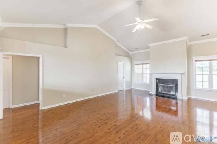 A spacious living room with a fireplace and hardwood floors.