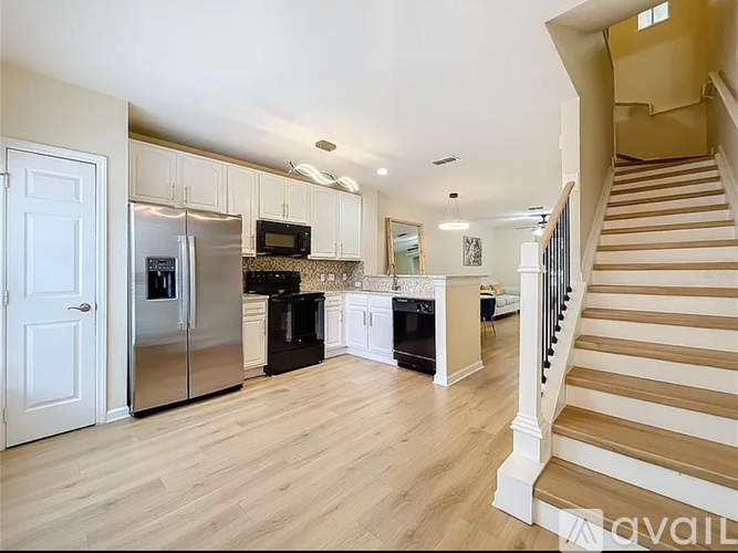 A kitchen with a refrigerator, microwave, oven, and sink.