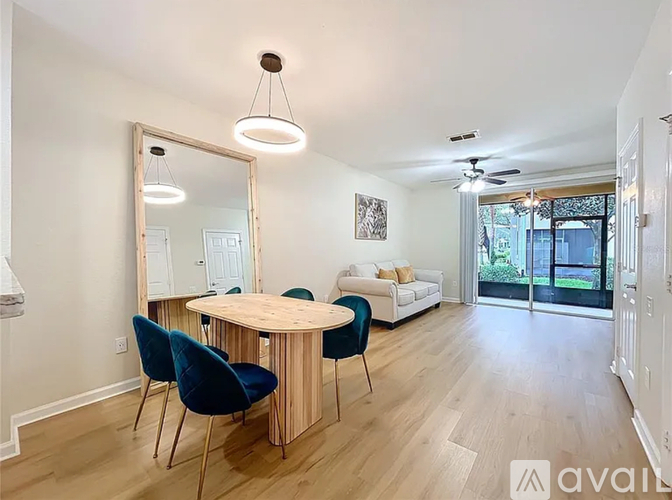 A living room with a round wooden table and blue chairs.